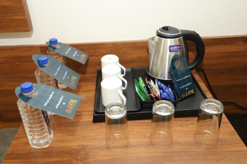 a table with a coffee maker and glasses on it at Suvin Residency with Rooftop Swimming Pool in Udaipur