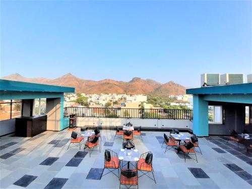 a patio with tables and chairs on a roof at Suvin Residency with Rooftop Swimming Pool in Udaipur