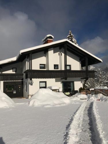 a house covered in snow with a road in front at Landhaus Zirben in Bad Kleinkirchheim