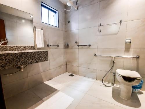 a bathroom with a toilet and a sink and a mirror at HUB Hotel in Teresina