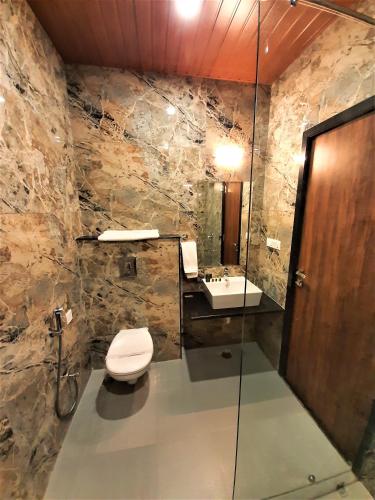 a bathroom with a toilet and a sink at Suvin Residency with Rooftop Swimming Pool in Udaipur