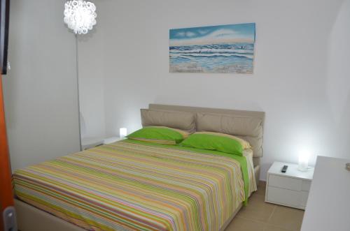 ポッツァッロにあるVacanze D'Autoreのベッドルーム1室(緑の枕と壁の絵付)