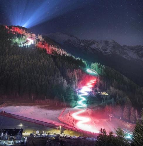 a mountain lit up at night with lights at Suite il sogno di Grebek in Passo del Tonale