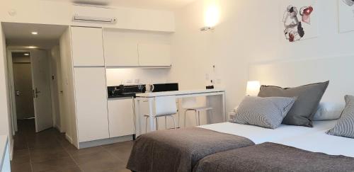 a bedroom with a bed and a small kitchen at RENTAL SUITES CAMPANA in Campana