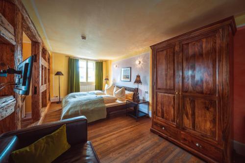 a bedroom with a bed and a large wooden cabinet at Ristorante e Pensione La Campagnola in Dresden