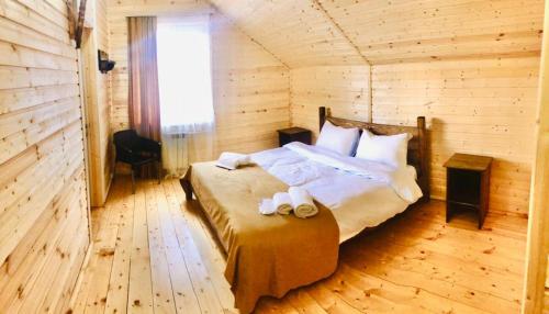 a bedroom with a bed in a wooden room at COTTAGE CHALET and TOURS in Dilijan