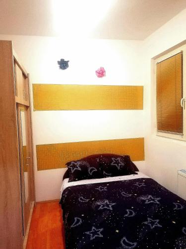 a bedroom with a bed with a wooden headboard at Jednosoban stan centar in Pirot