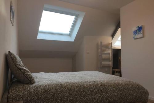 1 dormitorio con cama y ventana en APPARTEMENT T2, en Saint-Brieuc