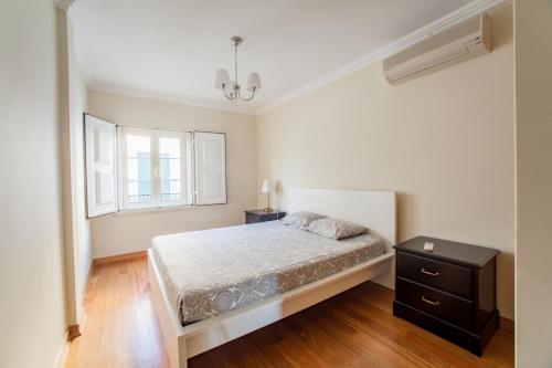 een witte slaapkamer met een bed en een raam bij Rio Gilao in Tavira