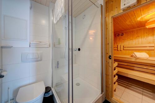 een badkamer met een douche en een toilet bij Landgasthof zum Dorfkrug in Häusern