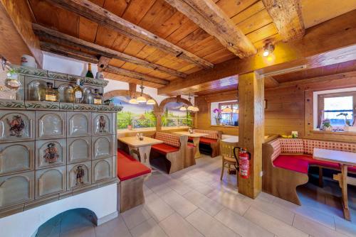 ein Restaurant mit Holzdecken, Tischen und Bänken in der Unterkunft Landgasthof zum Dorfkrug in Häusern