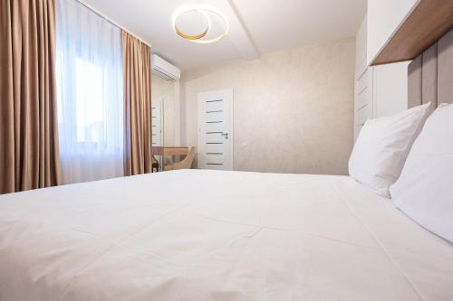 a bedroom with a large white bed and a window at Klia in Sînmartin