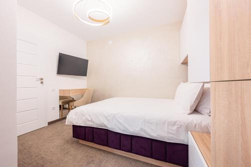 a hotel room with a bed and a tv at Klia in Sînmartin