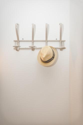 a hat hanging on a wall with a shelf at PALACIO Boutique in Anna