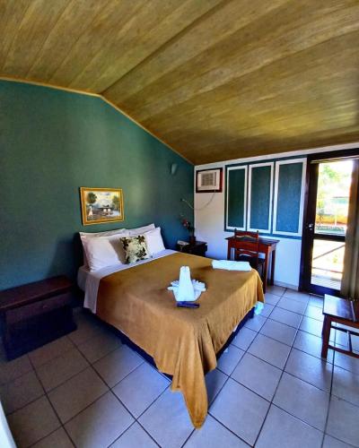 a bedroom with a large bed with a wooden ceiling at Hotel Jardim Tropical in Barcarena