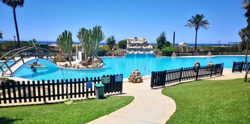 a large pool with a slide in a theme park at Apartamento el Atunito, Atlanterra in Zahara de los Atunes