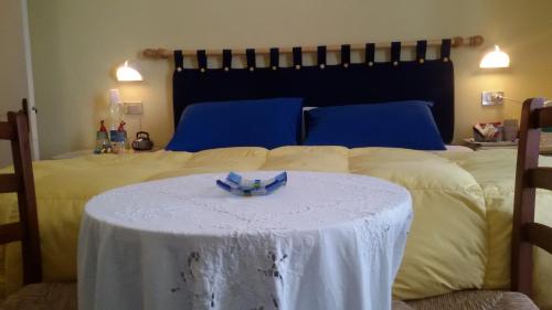a bed with a table with a white table cloth on it at B&B Il Giardino in Tavullia