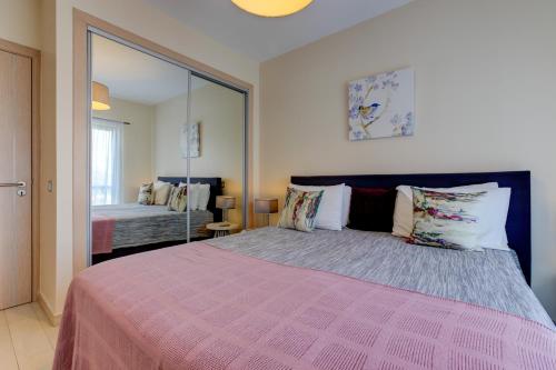 アルヴォルにあるOne Bedroom Apartment in Albur Village 1Cのベッドルーム(大型ピンクベッド、鏡付)