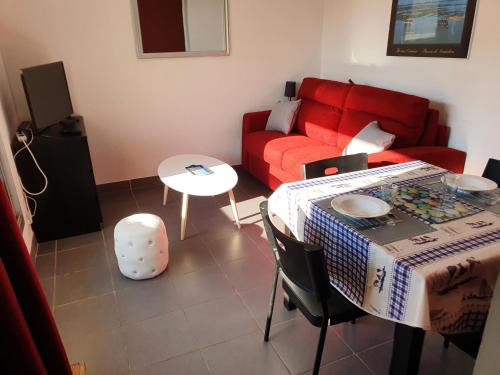 un salon avec un canapé rouge et une table dans l'établissement les Huniers Appt 1er étage, à Arcachon