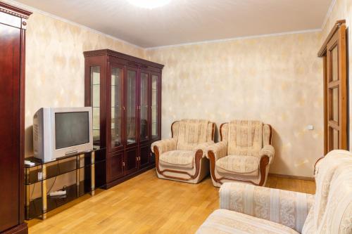 a living room with two chairs and a tv at Рыбальская 8 in Kyiv