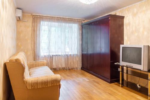 a living room with a tv and a chair and a tv stand at Рыбальская 8 in Kyiv