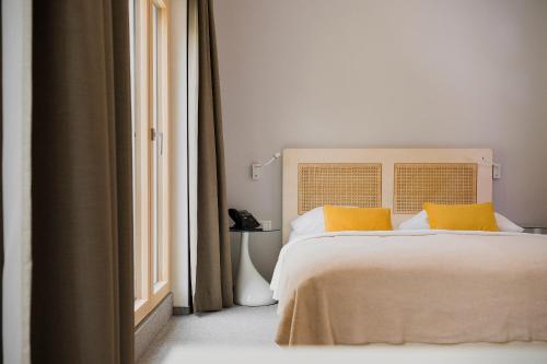 a bed with a white bedspread and a white comforter at Art Hotel in Ljubljana