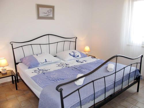 a bedroom with a bed with blue and white sheets at Apartment Tin in Pinezici