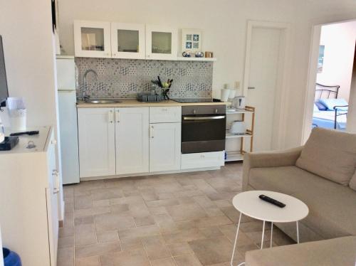 een keuken en een woonkamer met een bank en een tafel bij Apartment Tin in Pinezici
