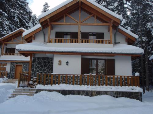 a house covered in snow in front at Saint George Holiday Village in Borovets
