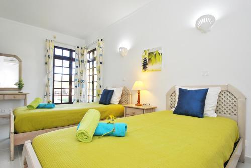 two beds in a room with yellow and blue at Villa Isa Joe by Algarve Vacation in Almancil