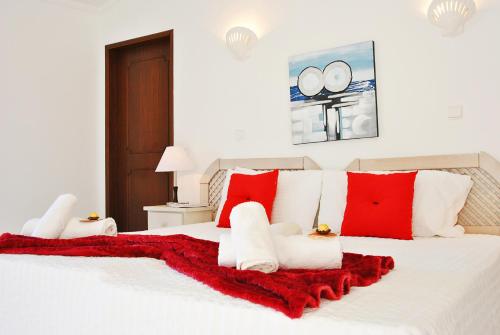 a large white bed with red and white pillows at Villa Isa Joe by Algarve Vacation in Almancil