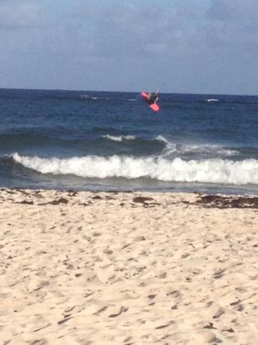 a person is in the air over the ocean at Sea Shells Villa in Christ Church