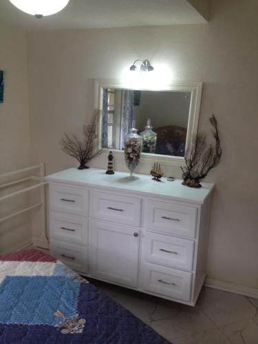 ein Badezimmer mit einer weißen Kommode und einem Spiegel in der Unterkunft Sea Shells Villa in Christchurch