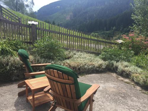 two chairs and a table with a view of a mountain at Das Hexenhäusl in Schmitten