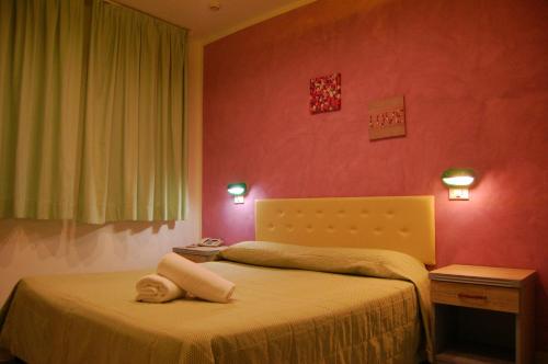 a bedroom with a bed with a doll laying on it at Bellevue del Golfo Hotel & Spa in Sferracavallo