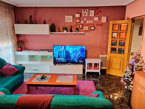 a living room with a green couch and a television at NorbeHouse in Zamora