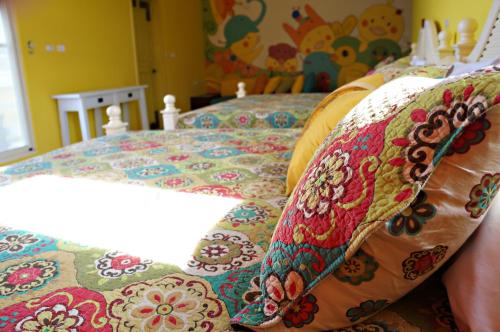a bed with colorful pillows on top of it at 依比鴨鴨水岸會館 Ducking House in Ruisui