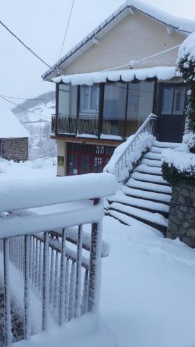 a house with stairs covered in snow at Les Planchettes in Orcival
