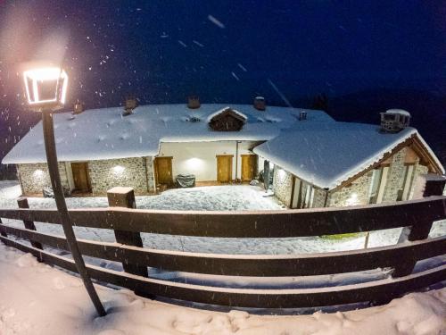 a house covered in snow at night with a street light at Apartamentos Los Picos de Europa in Colio