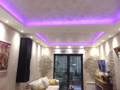 a living room with a ceiling with purple lights at Apartman S33 Vila Pekovic Green in Zlatibor