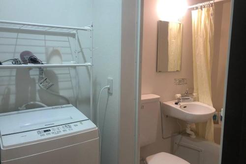 a small bathroom with a shower and a sink at 玉藻本町203 in Takamatsu