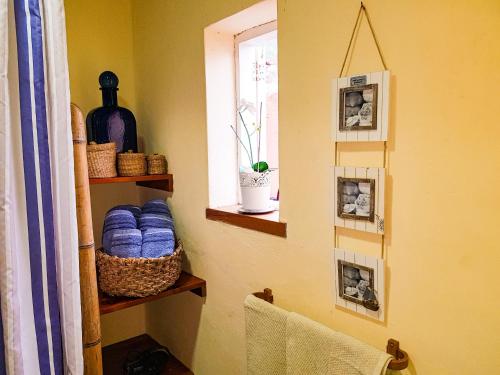 uma casa de banho com uma prateleira com toalhas azuis e uma janela em Apartmento Tabares em Tejina