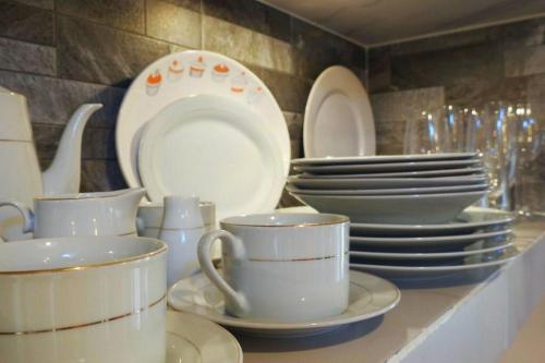 een aanrecht met borden, kopjes en borden bij Casa El Quinto Elemento, Departamento Fuego! in Isla Mujeres