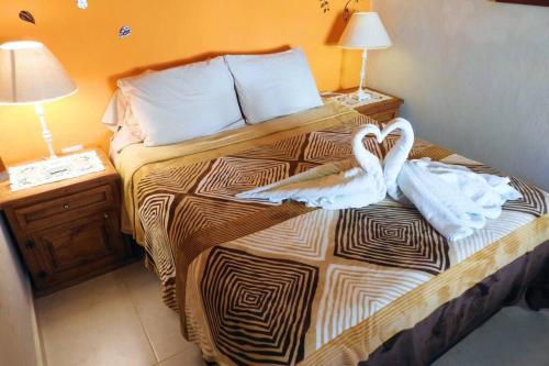 een hotelkamer met een bed met handdoeken erop bij Casa El Quinto Elemento, Departamento Fuego! in Isla Mujeres