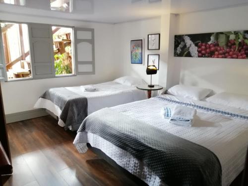 a bedroom with two beds and a window at La Estancia Hotel Boutique in Salamina