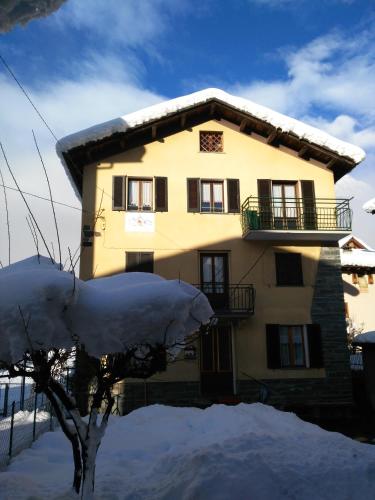 a house with snow on the ground in front of it at Tra le Vette in Caspoggio