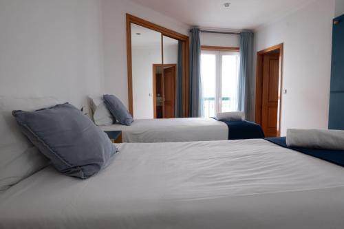 a hotel room with two beds and a mirror at InnEsposende Sports Hostel in Esposende