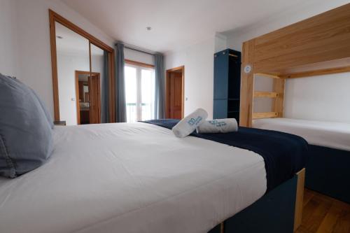 a large white bed with two pillows on top of it at InnEsposende Sports Hostel in Esposende
