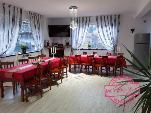 uma grande sala de jantar com mesas e cadeiras vermelhas em Memories Villa em Moieciu de Sus