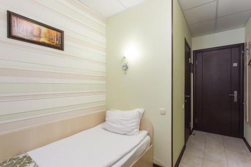 a small room with a bed and a door at Hotel Voyage in Kharkiv